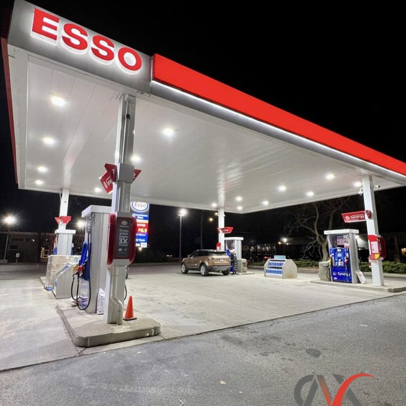Nighttime view of an Esso gas station with bright lighting and clean canopy.