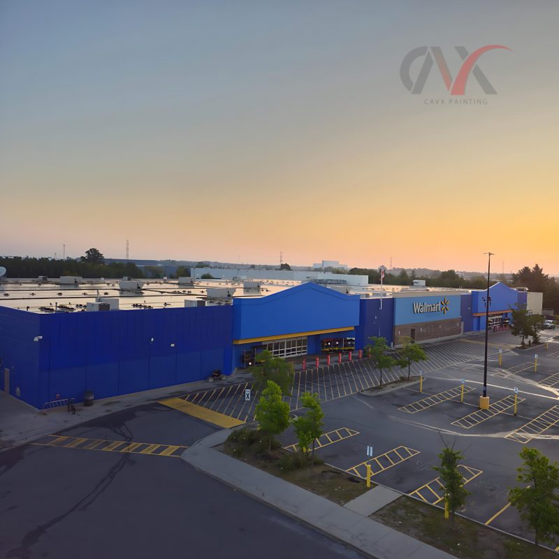 Exterior of a large blue Walmart building at sunset with parking area visible.