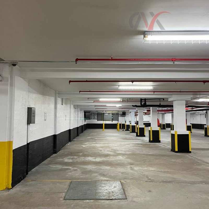 Clean parking garage with white, black, and yellow painted walls and pillars.
